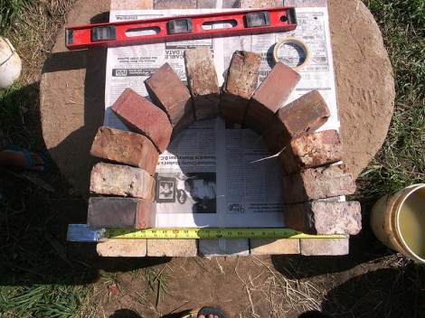 (Trazando el arco de ladrillo para hacer una forma de cartón, estableciendo los ladrillos en el molde de cartón).